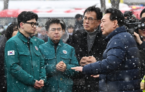 윤석열 대통령이 23일 충남 서천군 서천읍 서천특화시장 화재 현장에서 국민의힘 한동훈 비상대책위원장과 만나 함께 현장을 점검하고 있다.  홍윤기 기자