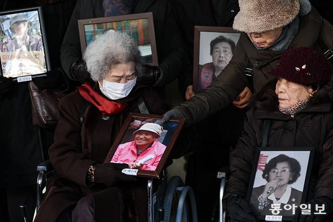 25일 오전 서울 서초구 대법원에서 열린 일제 강제동원 후지코시 상대 손배소송 상고심 선고에서 원고 일부승소 판결 원심이 확정된 뒤 피해자 김계남 할머니가 고(故) 배순례 씨의 사진을 들고 있다. 이한결 기자 always@donga.com