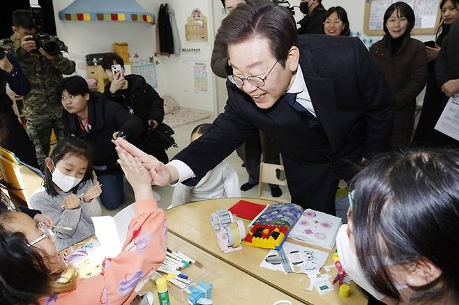 이재명 더불어민주당 대표가 지난 24일 경기 김포시 통진읍 청룡어린이집에서 아이들과 함께 손바닥을 마주치며 밝게 웃고 있다. 연합뉴스