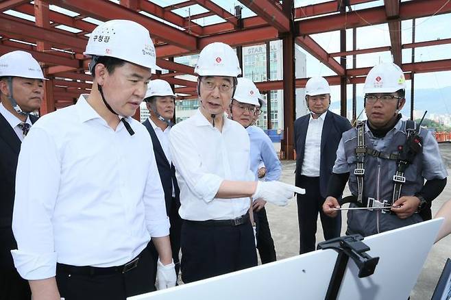 한덕수 국무총리가 도봉구 창동역 공사현장을 찾아 현장 점검을 하고 있다. 한 총리는 7월 집중호우 피해지역 경북 예천 사과즙을 현장근로자와 공무원들에게 선물했다. ⓒ뉴시스