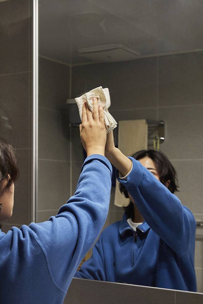 지인들로부터 ‘청소왕’이라고 불리는 유진하씨가 지난 19일 서울 동대문구 자신의 집에서 화장실 거울의 얼룩을 닦아내고 있다. 스튜디오 어댑터 염서정