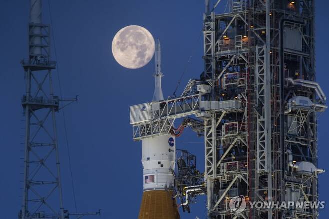 2026년으로 연기된 NASA 인류 달착륙 계획 (케네디 우주센터 AP=연합뉴스) 미국 항공우주국(NASA)이 유인 탐사선으로 달 궤도를 도는 아르테미스 프로그램 2단계 계획(아르테미스Ⅱ)을 내년 9월로, 우주비행사를 달에 착륙시키는 3단계(아르테미스Ⅲ) 계획을 2026년 9월로 연기한다고 9일(현지 시각) 밝혔다. 사진은 2022년 6월 14일 NASA 케네디 우주센터의 아르테미스Ⅰ대형 로켓 우주발사시스템(SLS)과 오리온 우주선 뒤로 보름달이 뜬 모습. [NASA 제공] 2024.01.10 besthope@yna.co.kr