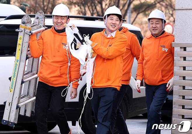 이준석 개혁신당 대표가 26일 오후 서울 여의도 국회 앞 가로수에 당의 첫 현수막을 설치하기 위해 이동하고 있다. 왼쪽부터 이기인 최고위원, 이 대표, 김용남 정책위의장. 2024.1.26/뉴스1 ⓒ News1 구윤성 기자