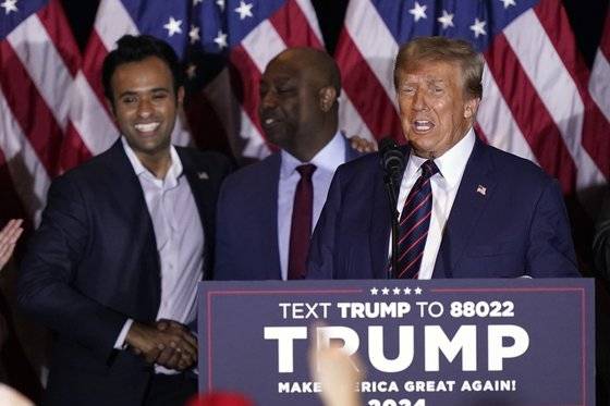트럼프 전 대통령이 23일 뉴햄프셔주 경선 승리 연설을 하는 동안 팀 스콧 상원의원(오른쪽)과 기업인 비벡 라마스와미가 무대에 함께 있다. AP=연합뉴스