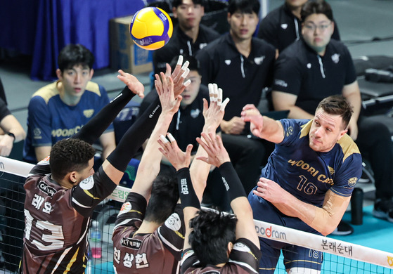 Seoul Woori Card Woori Won's Matej Kok, right, attacks during a V League game against Ansan OK Financial Group Okman at Jangchung Arena in central Seoul on Jan. 10. [NEWS1]