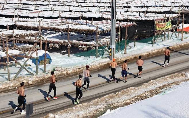 28일 강원 평창군 대관령 일원에서 열린 '2024 평창 대관령 알몸 마라톤대회'에서 참가자들이 황태덕장을 배경으로 달리고 있다.