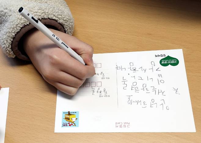 강원 양양 현남우체국 체험에 참여한 어린이들이 선생님과 친구들에게 손 글씨로 엽서를 쓰고 있다.