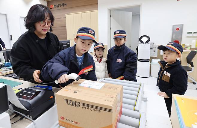 이정화 강원 양양 현남우체국장이 우체국에 체험 온 어린이들에게 택배가 접수되어 전국에 배달되는 과정에 대해 설명하고 있다.