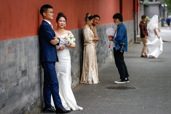중국의 신혼부부 커플들이 베이징 자금성 성벽에서 기념 촬영을 하고 있다. 중국은 지난해 61년만에 마이너스 인구성장을 기록한 이후 올해에도 208만명의 인구 감소를 기록했다. EPA=연합뉴스