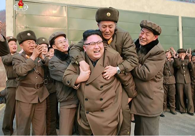 김정은 북한 노동당 위원장이 2017년 3월 18일 서해위성발사장에서 신형 고출력 로켓엔진 지상분출시험을 참관한 뒤 국방과학·기술 책임자로 추정되는 관계자를 등에 업고 있다. 등에 업힌 관계자는 감격에 겨워 눈물을 흘리고 있다. 김정은은 시험 결과에 만족감을 표시하면서 국방과학자와 기술자들을 얼싸안거나 등에 업으며 노고를 위로했다./조선중앙TV-연합뉴스