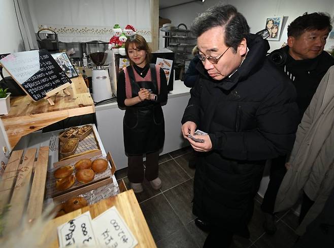 [광주=뉴시스] 이영주 기자 = 이낙연 전 더불어민주당 대표가 24일 오후 광주 동구 남광주시장을 찾아 상인들과 인사하며 물건을 사고 있다. 2024.01.24.