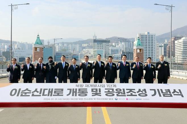 부산항만공사(사장 강준석·왼쪽 일곱번째)가 주최한 부산항 북항재개발지역 관통 이순신대로 개통 기념식 참석자들이 기념촬영을 하고 있다. 부산항만공사 제공