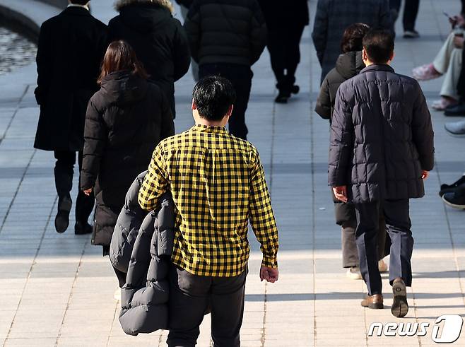 낮 기온이 최고 13도까지 올라가 포근한 날씨를 보인 31일 서울 청계천에서 한 시민이 외투를 손에 든 채 이동하고 있다. 2024.1.31/뉴스1 ⓒ News1 박지혜 기자