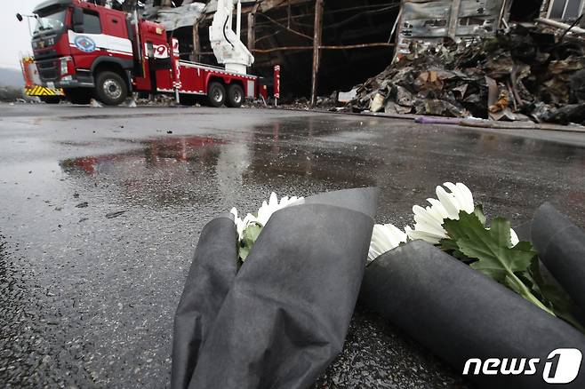 1일 오후 경북 문경시 신기동 육가공업체 공장 화재 현장 통제선 앞에 소방공무원 출신 오영환 더불어민주당 의원 일행이 순직 소방관을 애도하며 헌화한 국화가 놓여 있다. 전날 오후 7시47분쯤 이 공장에서 원인을 알 수 없는 불이 나 현장에 투입된 구조대원 2명이 순직했다. 2024.2.1/뉴스1 ⓒ News1 공정식 기자