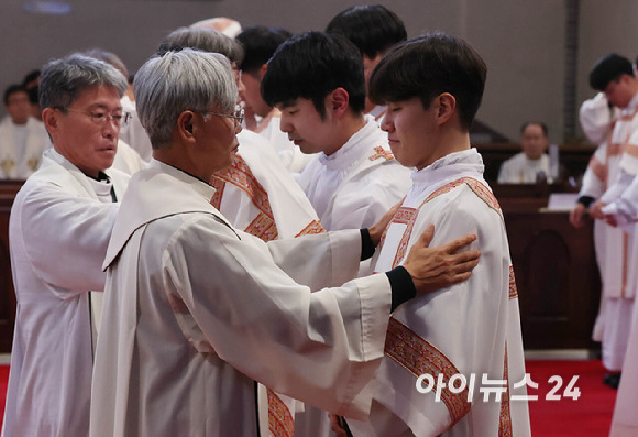 2024년 천주교 서울대교구 부제 서품식이 열린 1일 서울 중구 명동대성당에서 추천 사제들이 부제 수품자들에게 달마티카(부제복)를 입혀주고 있다. [사진= 사진공동취재단]