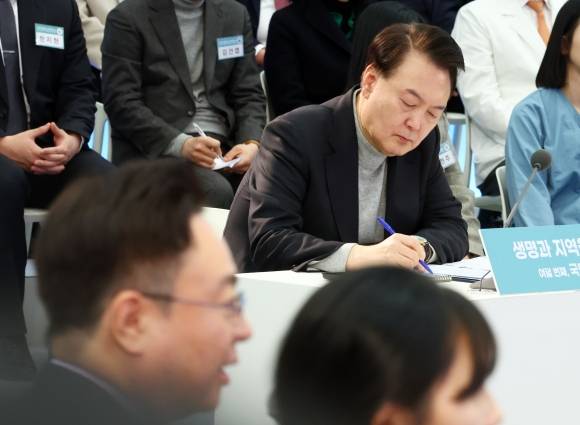 윤석열 대통령이 1일 경기도 성남시 분당서울대병원에서 열린 ‘국민과 함께하는 민생토론회-여덟 번째, 생명과 지역을 살리는 의료개혁’에서 메모하고 있다. 연합뉴스