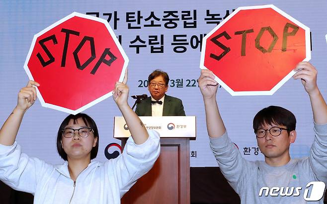 국가탄소중립 녹색성장 기본계획 수립 등에 대한 공청회에서 김상협 위원장이 발언하고 있는 가운데 환경단체 회원들이 기본계획 철회를 촉구하며 피켓 시위를 하고 있다. 2023.3.22/뉴스1 ⓒ News1 박세연 기자