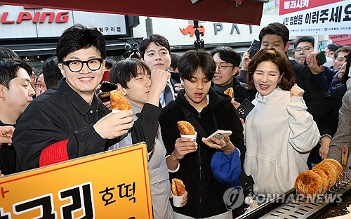 (구리=연합뉴스) 한상균 기자 = 국민의힘 한동훈 비상대책위원장이 설 명절을 앞둔 2일 오후 경기도 구리시 구리전통시장을 방문해 호떡을 구입한 뒤 상인과 대화하고 있다. 2024.2.2 [공동취재] xyz@yna.co.kr