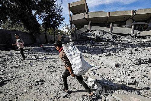 가자지구에서 UNRWA 적힌 봉지 들고가는 소년 [AFP=연합뉴스 자료사진]