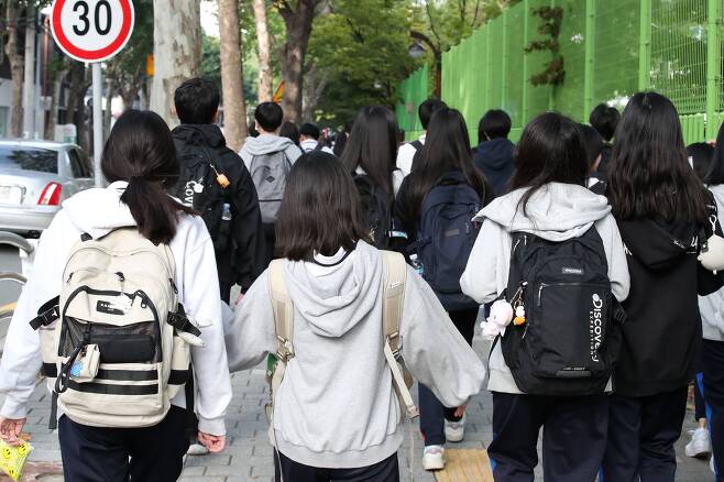 서울의 한 중학교 학생들이 등교하는 모습. 요즘 중2병이 옛날 사춘기보다 더 다루기 힘들어지는 이유는 극단적 핵가족화, 과열된 입시 경쟁, 극단적이고 자극적인 인터넷 정보의 범람 때문이라는 분석이 나온다. (특정 사진은 기사와 관련 없음) /뉴스1