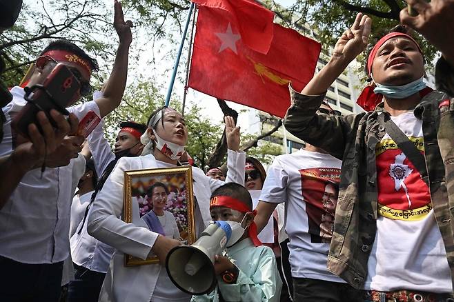 미얀마 군부 쿠데타 3주년을 맞은 2월 1일, 타이 방콕의 유엔사무소 밖에서 미얀마 국기와 아웅산 수치 사진을 든 사람들이 군정 종식을 촉구하고 있다. 미얀마 군사정부는 전날 국가비상사태를 오는 7월 31일까지 6개월 연장했다. 방콕/AFP 연합뉴스