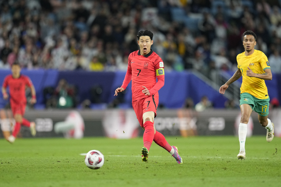 Korea's Son Heung-min, center, passes the ball as Australia's Keanu Baccus, right, challenges.  [AP/YONHAP]