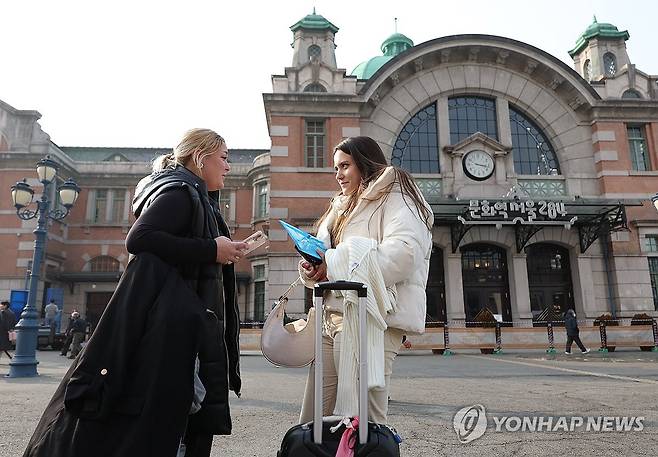 포근한 서울 (서울=연합뉴스) 김성민 기자 = 낮 최고기온이 7~13도로 평년보다 높은 포근한 날씨를 보인 2일 오후 서울역 인근에서 외국인 관광객들이 겉옷을 손에 들고 대화를 나누고 있다. 2024.2.2 ksm7976@yna.co.kr