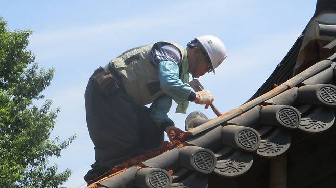 ▲ 광주 일원의 문화유산은 모두 김귀백 팀장의 손길이 닿아 있다. 사진은 한옥 지붕 기와고르기 작업 모습