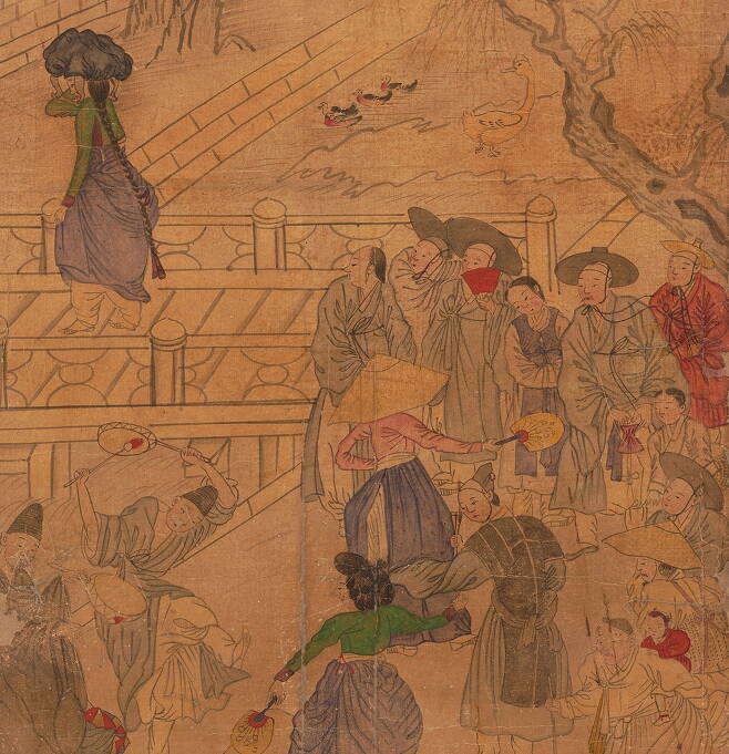 다리 주변의 풍경을 묘사한 조선 풍속화. 신명 난 놀이판이 한창인 가운데 남자들이 다리를 건너가는 젊은 여성을 쳐다보고 있다. 국립중앙박물관