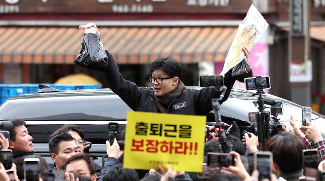 국민의힘 한동훈 비상대책위원장이 설 명절 연휴를 나흘 앞둔 2월5일 서울 동대문구 청량리 청과물시장·경동시장을 방문해 구매한 상품을 들어보이며 시민들과 인사를 나누고 있다. ⓒ공동취재