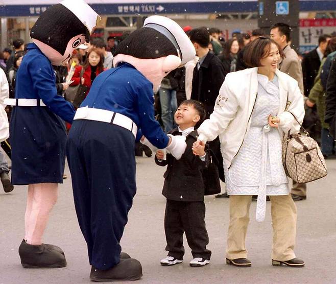 2000년 2월 3일 오후 엄마와 함께 귀성길에 오른 한 어린이가 서울역 광장에서 마스코트 복장을 한 경찰 아저씨의 배웅을 받으며 즐거워하고 있다. 한겨레 자료사진