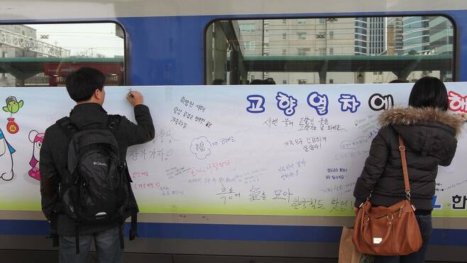 2012년 1월 20일 서울역에서 귀성객들이 열차에 걸린 펼침막에 새해 소원을 적고 있다. 강창광 선임기자 chang@hani.co.kr