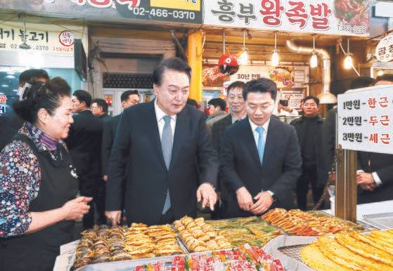 윤석열 대통령이 8일 서울 성동구 복합문화공간인 레이57에서 '국민과 함께하는 민생토론회 - 열 번째, 함께 뛰는 중소기업·소상공인, 살맛나는 민생경제'를 마친 뒤 광진구 중곡제일시장내 한 전집을 방문해 상인들을 격려하고 있다. 김현동 기자