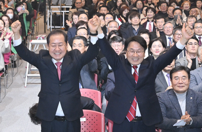 7일 오후 광주 김대중컨벤션센터에서 열린 달빛철도 특별법 국회 통과 축하 행사에서 홍준표(왼쪽) 대구시장과 강기정 광주시장이 손을 잡고 기뻐하고 있다.   대구시청 제공