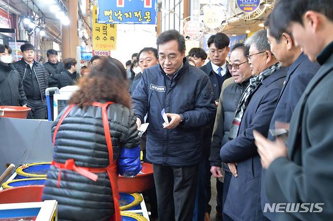 [목포=뉴시스] 박상수 기자 = 8일 오전 전남 목포 동부시장을 방문한 새로운미래 이낙연 공동대표가 낙지를 구매한 뒤 돈을 지불하고 있다. 2024.02.08. parkss@newsis.com
