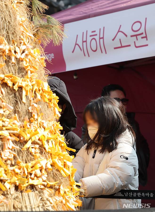 [서울=뉴시스] 권창회 기자 = 설날인 10일 오후 서울 중구 남산골한옥마을에서 열린 '청룡이 복 나르샤' 설축제에서 어린이가 새해 소원을 걸고 있다. 2024.02.10. kch0523@newsis.com