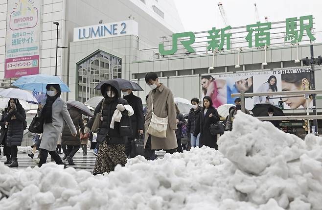 6일 일본 도쿄에서 시민들이 전날 내린 폭설로 눈이 쌓여 있는 신주쿠역 앞 교차로를 건너고 있다. 전날 도쿄 도심에 내린 폭설로 크고 작은 사고가 발생, 약 40명이 다쳤고 항공편과 철도 운행에 차질을 빚었다. 도쿄=AP/뉴시스