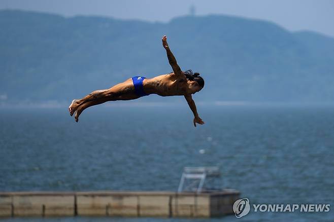 '하이 다이버' 최병화 (도하 EPA=연합뉴스) 최병화가 13일 카타르 도하 올드 도하 포트 특설 무대에서 열린 2024 세계수영선수권 하이 다이빙 남자부 경기에서 연기를 펼치고 있다.