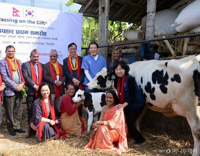 사진 뒷줄 왼쪽부터 네팔 카말라마이 우펜드라 포카렐 시장, 네팔 농림축산개발부 르와티 푸델 차관, 박태영 주네팔 대사, 서을우유 파주유우소 김영찬 수의사가 자리를 함께 했다.  사진 앞줄 왼쪽부터 헤퍼네팔 니나조쉬, 한국에서 기증한 젖소 '토살이' 수혜자 구나 쿠마리, 탄생한 암송아지 '감사'를 받게 될 우마 수베디, 헤퍼코리아 이혜원대표가 환하게 웃고 있다.
