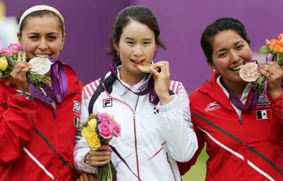 2012년 8월 2일(현지시간) 런던올림픽 양궁장 로즈 크리켓 그라운드에서 열린 양궁 여자 개인 결승전에서 금메달을 차지한 기보배 선수가 금메달을 깨물고 기념촬영을 하고 있다.  이날 기보배 선수는 슛오프까지 가는 접전 끝에 아이다 로만(멕시코)을 꺾었다. 런던 올림픽사진공동취재단