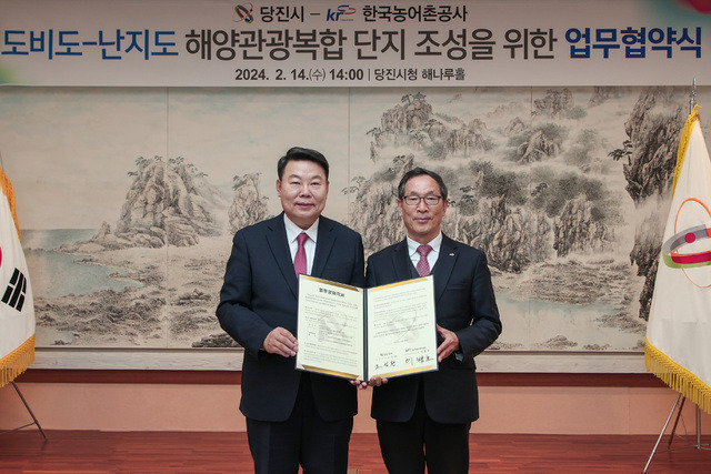 14일 충남 당진시청에서 열린 ‘도비도·난지도 해양관광복합단지 조성을 위한 업무협약식’에서 오성환 당진시장(왼쪽)과 이병호 한국농어촌공사 사장이 협약서를 들어보이며 신속한 단지 조성을 다짐하고 있다.