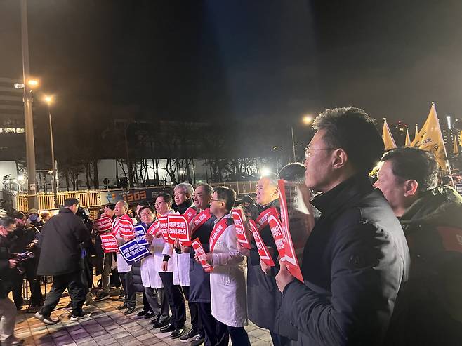 Clad in white gowns, high-level members of the Seoul Medical Association stage a rally in protest against the government’s decision to increase the medical school enrollment quota by 2,000 from the current 3,058 in front of the War Memorial of Korea in Yongsan, central Seoul, near the Presidential Office, Thursday night. (Park Jun-hee/The Korea Herald)