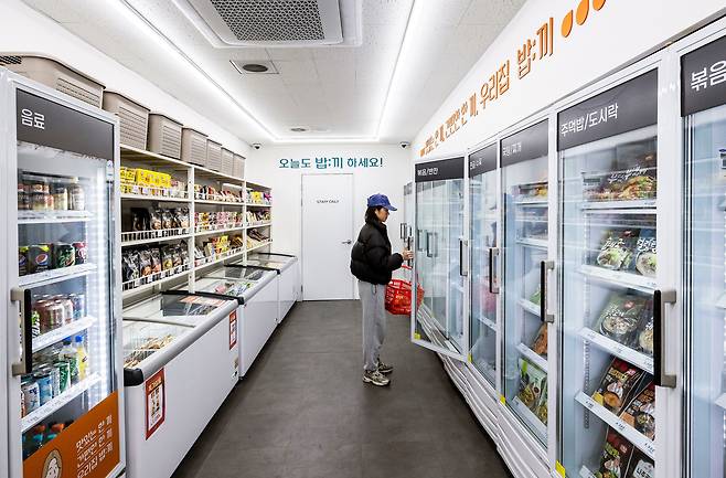설 연휴 직후인 13일 저녁 서울 관악구 신림역 인근의 무인 편의점에서 한 여성이 냉동 식품으로 장을 보고 있다. 열에 아홉이 1인 가구인 이 지역 상권은 1인분·소용량·비대면 위주의 일상을 떠받치도록 설계돼있다. /양수열 영상미디어 기자