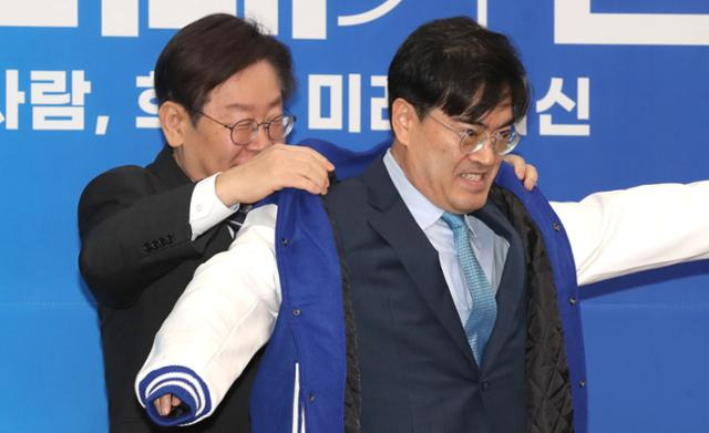 이재명(왼쪽) 더불어민주당 대표가 22일 국회에서 열린 9차 인재영입식에서 공영운 전 현대자동차 사장에게 당 점퍼를 입혀주고 있다. 고영권 기자