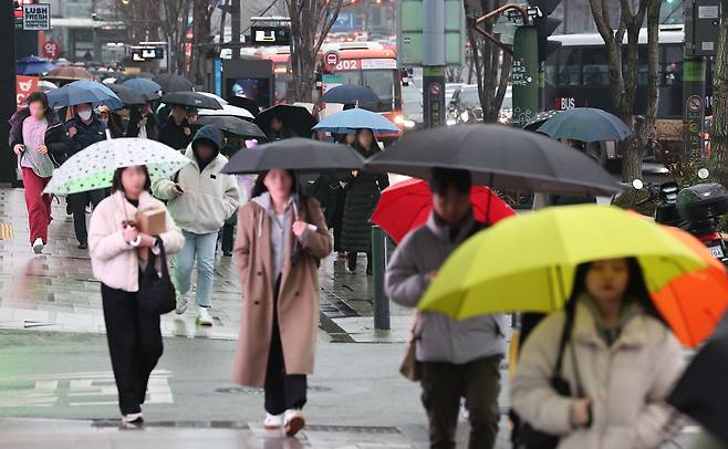 지난15일 오전 서울 강남역 인근 강남대로에서 시민들이 우산을 쓴 채 걸어가고 있다. [연합]