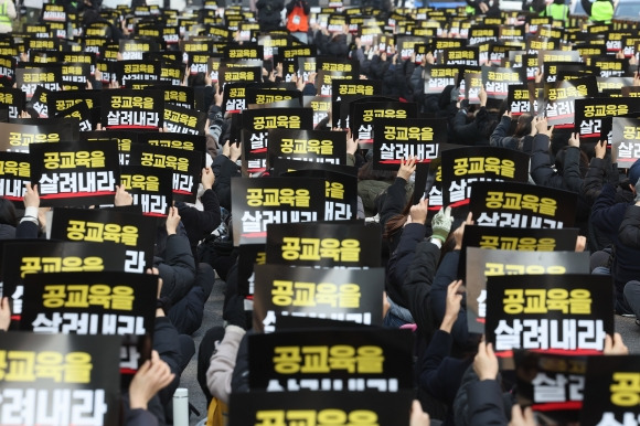 전국에서 모인 교사들이 17일 서울 중구 을지로입구역 인근에서 열린 ‘서이초 교사 순직 인정 촉구 및 늘봄 정책 규탄 집회’에서 손팻말을 들고 있다. 연합뉴스