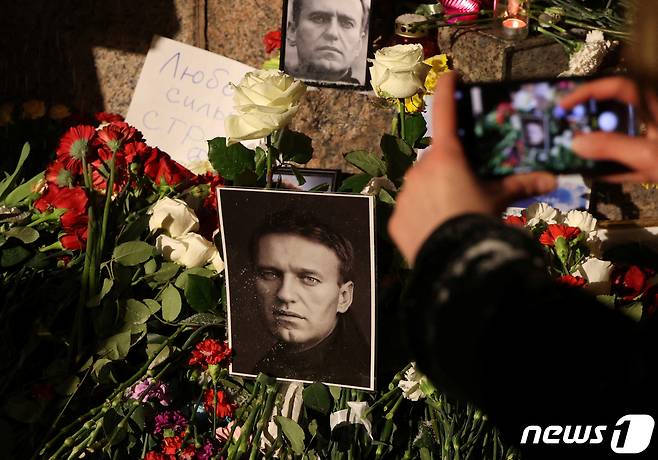 16일(현지시간) 러시아 상트페테르부르크에서 시민들이 야권 정치인 알렉세이 나발니의 사망 소식에 그를 추모하며 꽃과 촛불, 사진 등을 놓고 있다. 2024.02.16/ ⓒ 로이터=뉴스1 ⓒ News1 박재하 기자