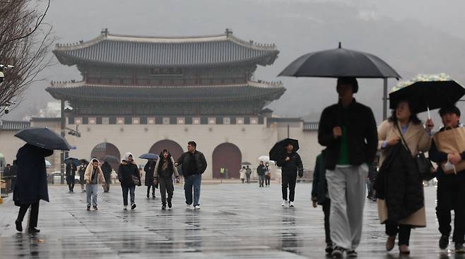 서울을 비롯한 전국에 비가 예보된 18일 오후 서울 종로구 광화문광장에서 시민들이 우산을 쓰고 이동하고 있다. 2024.02.18./뉴시스