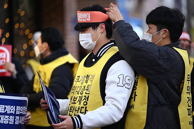 광주·전남지역 의대생들이 15일 오후 광주 서구 국민의힘 광주시당 앞에서 열린 ‘윤석열 케어 규탄 대회’에 참여해 서로의 머리띠를 묶어주고 있다. 광주=뉴시스