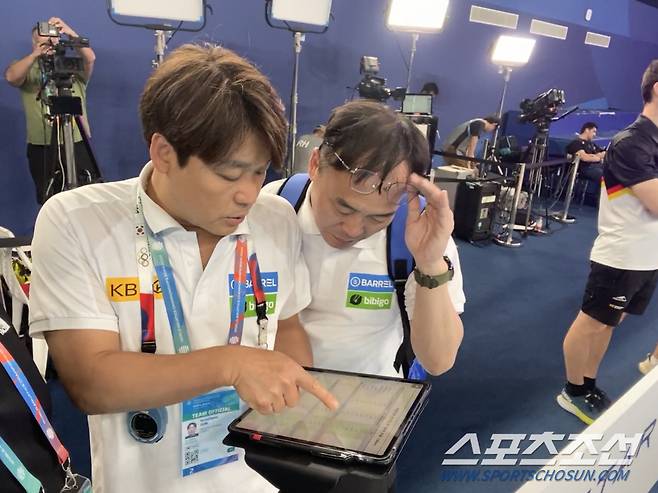 수영대표팀 이정훈 총감독(오른쪽)과 전동현 코치가 선수들의 예선 데이터를 실시간으로 확인하며 이야기를 나누고 있다.
